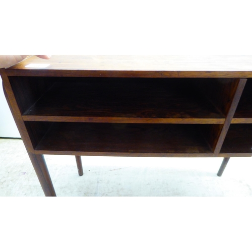 28 - A 1960s Danish rosewood side table with a low galleried top, over two enclosed shallow shelves, rais... 