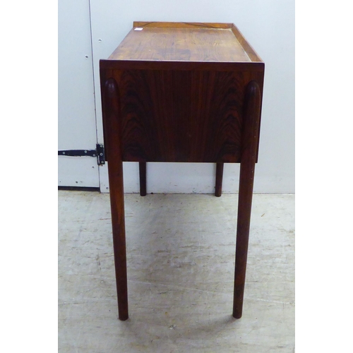 28 - A 1960s Danish rosewood side table with a low galleried top, over two enclosed shallow shelves, rais... 