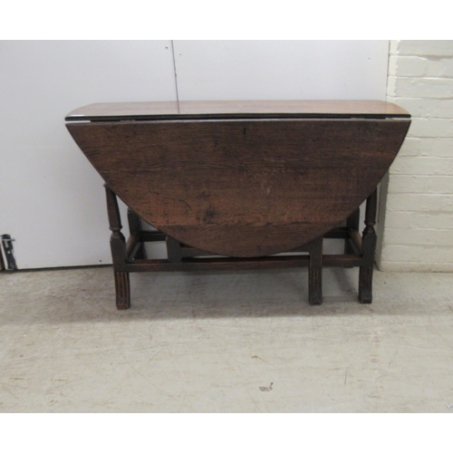 33 - An 18th/19thC oak gateleg table, the oval planked and dowelled top over an end drawer, raised on a r... 