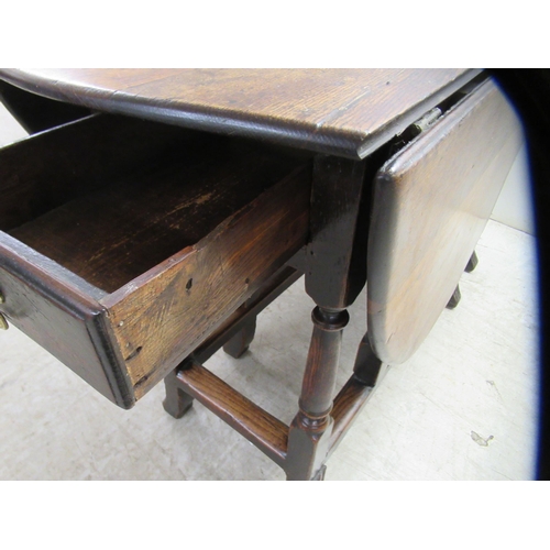 33 - An 18th/19thC oak gateleg table, the oval planked and dowelled top over an end drawer, raised on a r... 