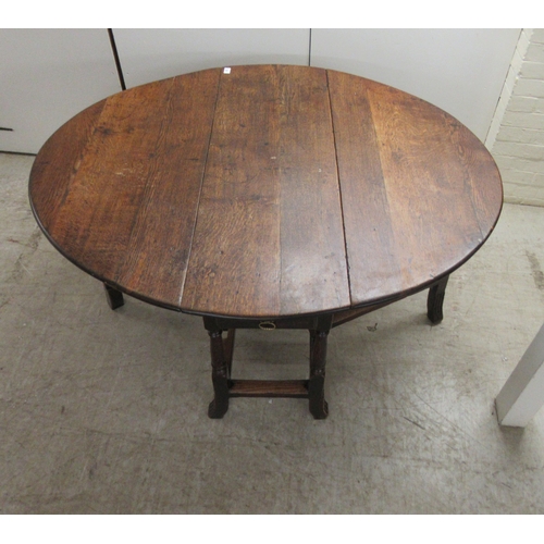 33 - An 18th/19thC oak gateleg table, the oval planked and dowelled top over an end drawer, raised on a r... 