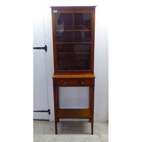 44 - An Edwardian satin mahogany veneered two part table cabinet, comprising a lockable fully glazed and ... 