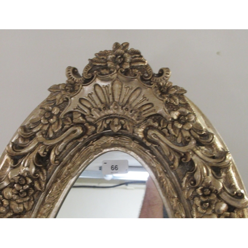 66 - A pair of Victorian style oval dressing mirrors, set in ornately moulded gilt frames, on folding eas... 