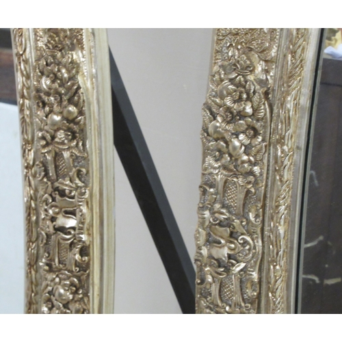 66 - A pair of Victorian style oval dressing mirrors, set in ornately moulded gilt frames, on folding eas... 