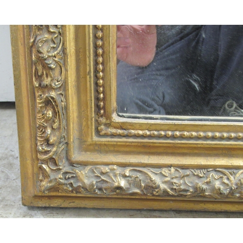 76 - A modern Victorian style dressing mirror, set in a bead moulded, foliate scrolled gilt frame, incorp... 