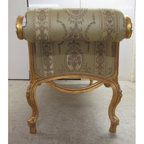 96 - A modern Louis XV inspired, carved giltwood framed window seat with scrolled ends and a shaped apron... 