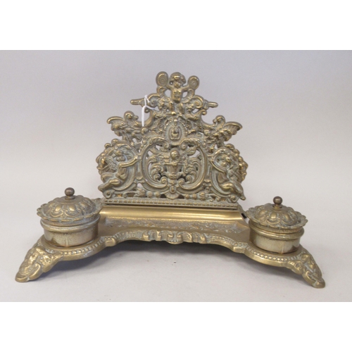 97 - A Victorian style brass deskstand, incorporating a letter rack, a pen channel and a pair of inkwell ... 