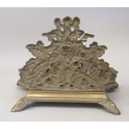 97 - A Victorian style brass deskstand, incorporating a letter rack, a pen channel and a pair of inkwell ... 