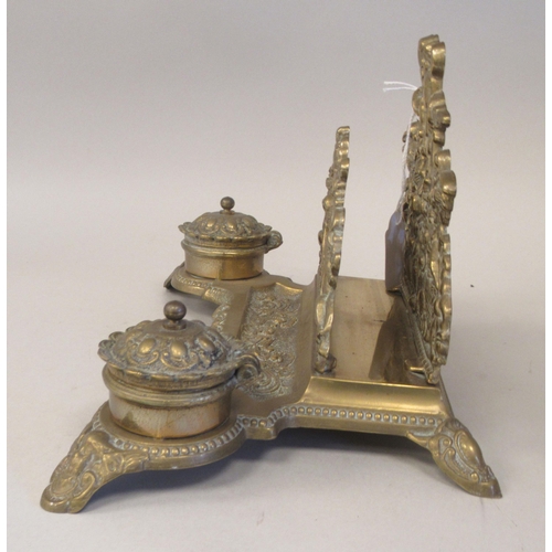 97 - A Victorian style brass deskstand, incorporating a letter rack, a pen channel and a pair of inkwell ... 