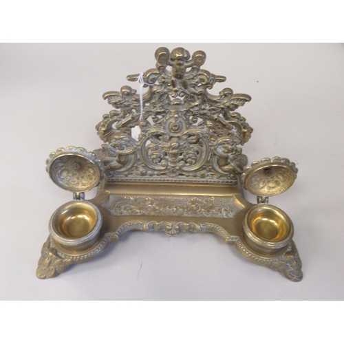 97 - A Victorian style brass deskstand, incorporating a letter rack, a pen channel and a pair of inkwell ... 