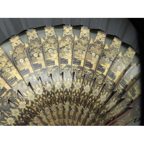 100 - An early 20thC Chinese lacquered and gilded fan, the sticks incorporating standing figures  the guar... 