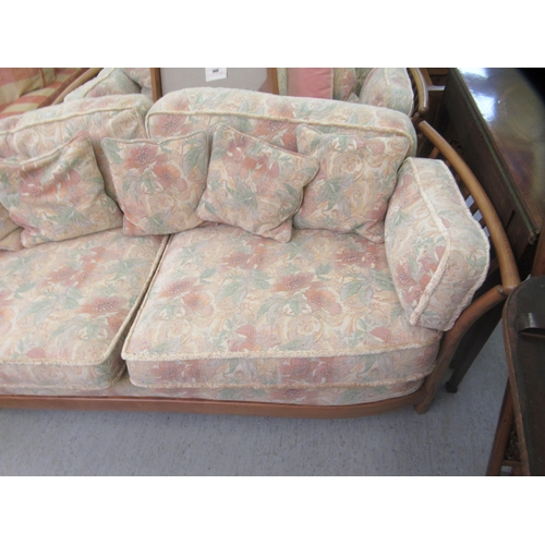 192 - A modern Ercol Renaissance elm and oak framed three person settee with floral patterned cushions