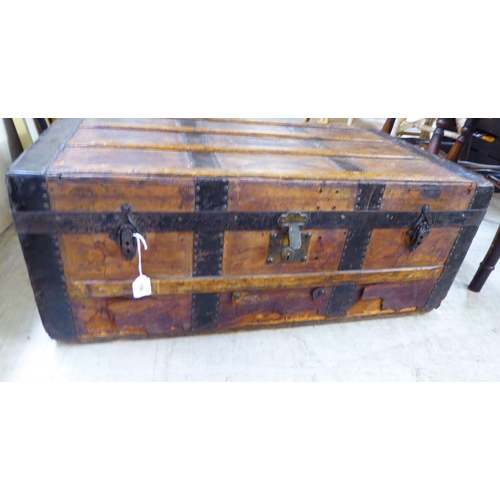 196 - A late 19th/early 20thC hide covered studded tinplate and beech bound cabin trunk with iron fittings... 