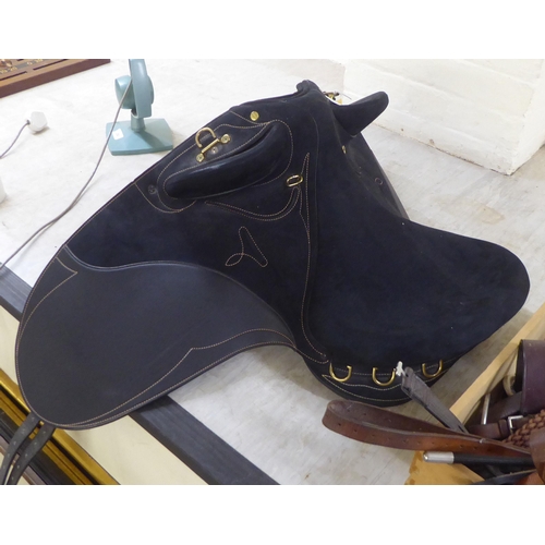 197 - A modern Wintec stitched black fabric saddle with brass fittings with a miscellany of horse riding t... 