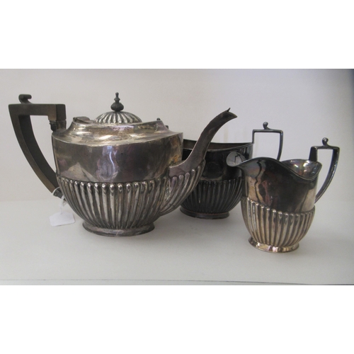 2 - An early 20thC silver three piece tea set of oval demi-reeded form  comprising a teapot, sugar ... 