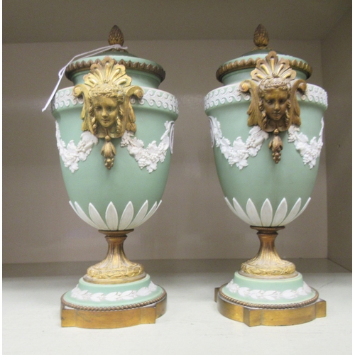 24 - A pair of Wedgwood green Jasperware and gilt metal mounted pedestal urn and cover, decorated with fr... 