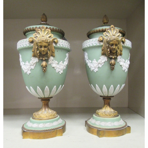 24 - A pair of Wedgwood green Jasperware and gilt metal mounted pedestal urn and cover, decorated with fr... 