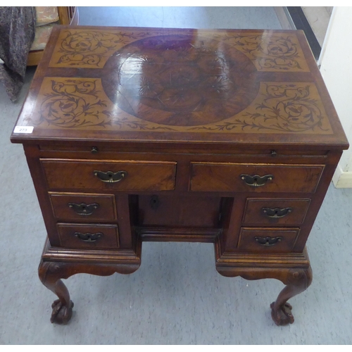 273 - An early 19thC carved satinwood and walnut inlaid desk, the top with marquetry decoration over a cen... 