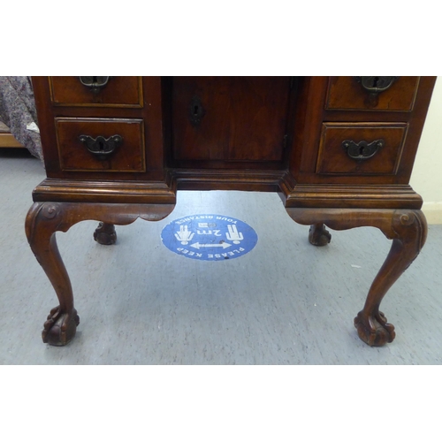 273 - An early 19thC carved satinwood and walnut inlaid desk, the top with marquetry decoration over a cen... 