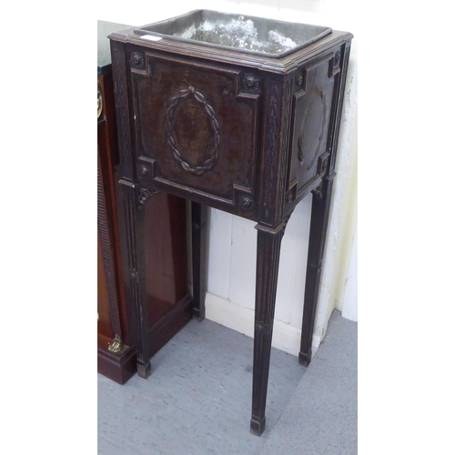 275 - An Edwardian mahogany jardiniere stand with a tinplate liner, the front panel decorated with a garla... 