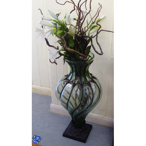 35 - A modern metal bound glass floorstanding vase with a faux flower display  40