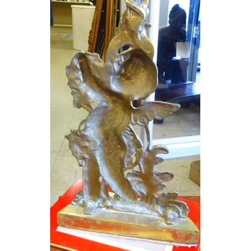 43 - A 20thC cast brass door porter, fashioned as a cherub holding grapes with additional foliage ornamen... 