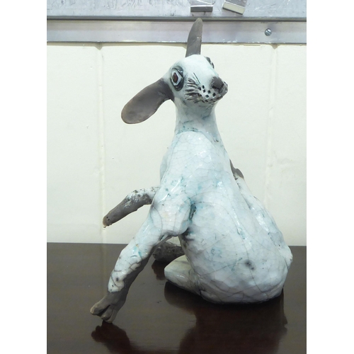 53 - Five 20thC crackle glazed and overpainted model animals, viz. a cow, a hare, a rabbit, a spaniel and... 