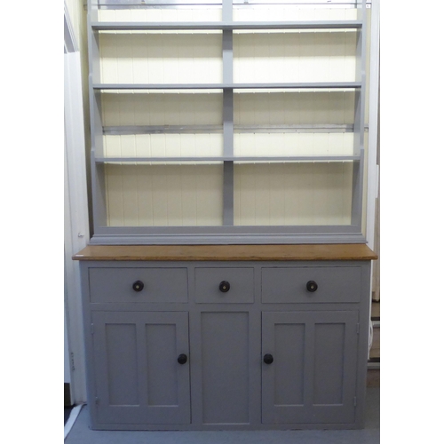 76 - An early 20thC later painted grey, pine kitchen dresser, the upper section comprising three open she... 