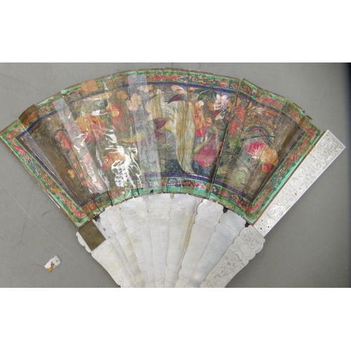 95 - An early 20thC engraved mother-of-pearl and painted paper fan, featuring standing figures  the guard... 