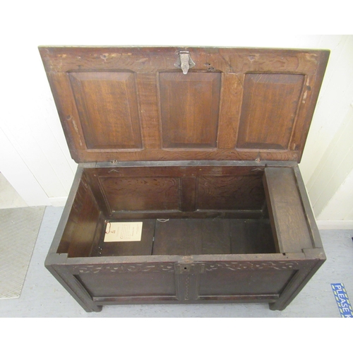 230 - An early 19thC panelled oak coffer with straight sides and a hinged lid, raised on block feet  ... 