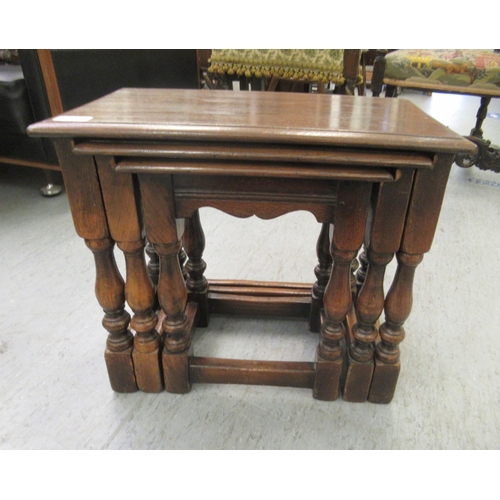 52 - A nesting set of three 20thC Old English style, stained oak occasional tables  largest 17