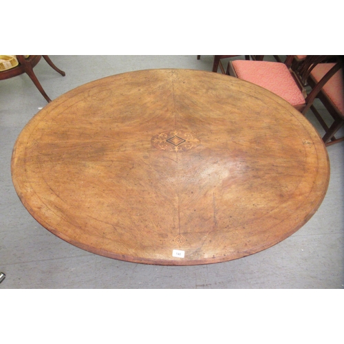 140 - A late Victorian walnut breakfast table, the oval, quarter veneered tip top with marquetry ornament,... 