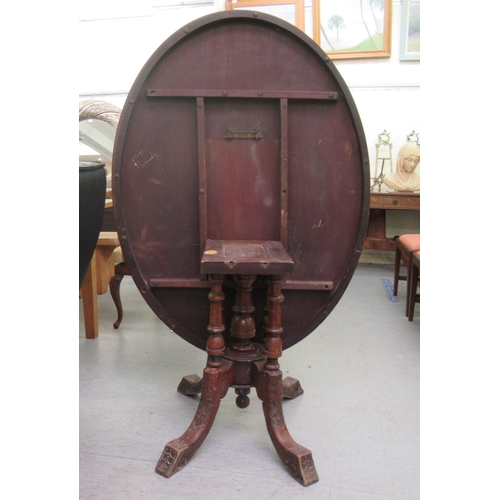 140 - A late Victorian walnut breakfast table, the oval, quarter veneered tip top with marquetry ornament,... 