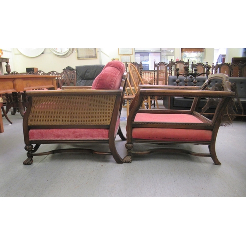 223 - A pair of early 20thC bergere chairs (one restored), raised on carved block legs united by stretcher... 