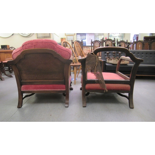 223 - A pair of early 20thC bergere chairs (one restored), raised on carved block legs united by stretcher... 