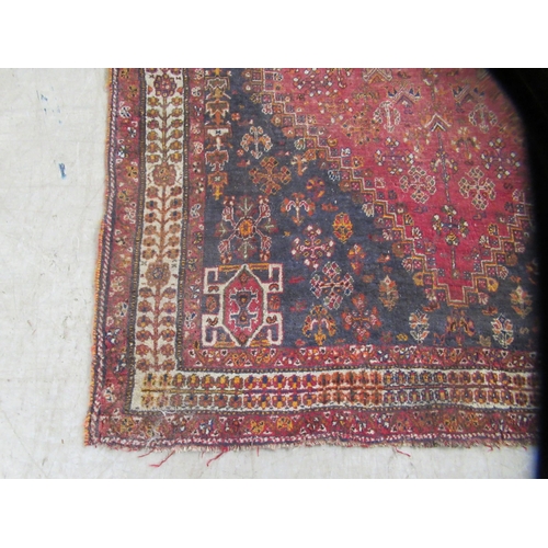 231 - An Indian woolen rug, decorated with stylised designs, on a rust coloured ground  65