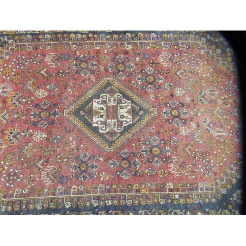 231 - An Indian woolen rug, decorated with stylised designs, on a rust coloured ground  65