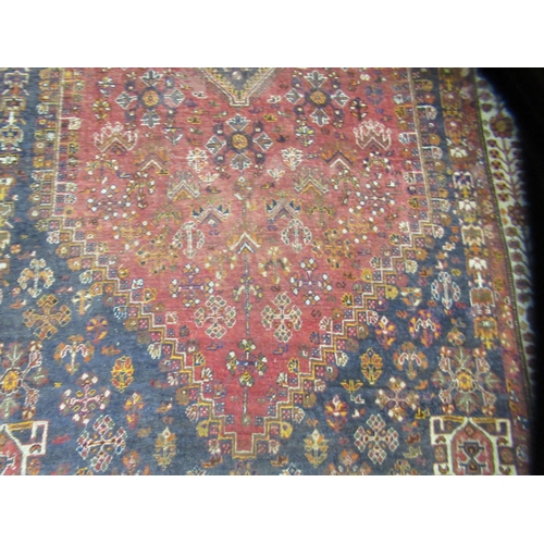 231 - An Indian woolen rug, decorated with stylised designs, on a rust coloured ground  65