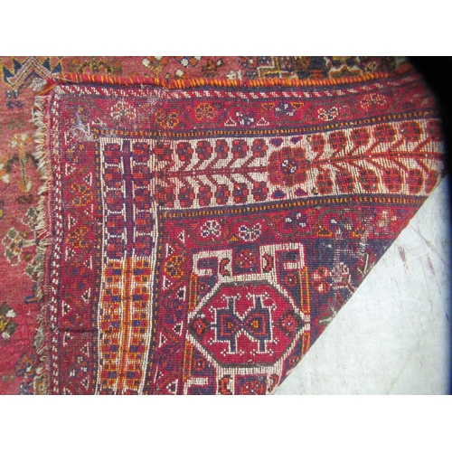 231 - An Indian woolen rug, decorated with stylised designs, on a rust coloured ground  65