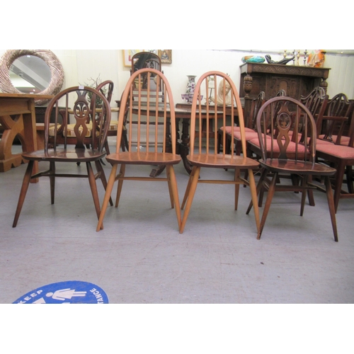 265 - Four similar Ercol stained beech framed spindle back chairs, raised on turned legs