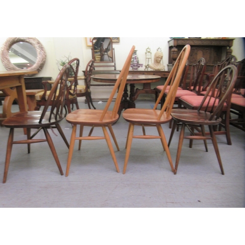 265 - Four similar Ercol stained beech framed spindle back chairs, raised on turned legs