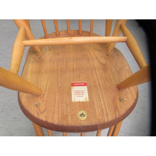 265 - Four similar Ercol stained beech framed spindle back chairs, raised on turned legs