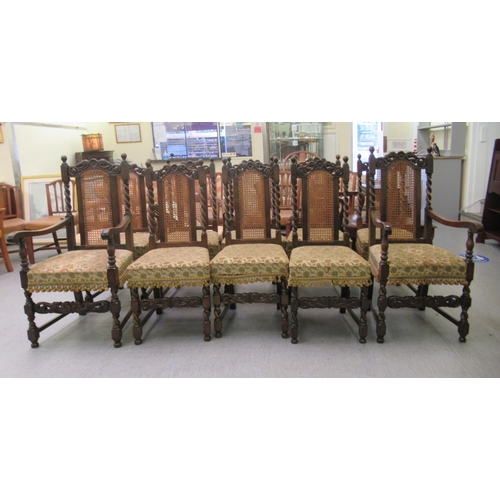 272 - A set of ten 1920s/1930s Carolean style oak framed dining chairs, each with a rosette carved crest, ... 