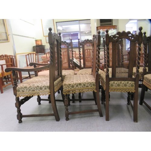 272 - A set of ten 1920s/1930s Carolean style oak framed dining chairs, each with a rosette carved crest, ... 