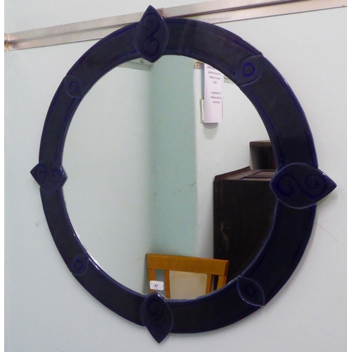 47 - A modern plaster, glazed ceramic effect framed mirror  34