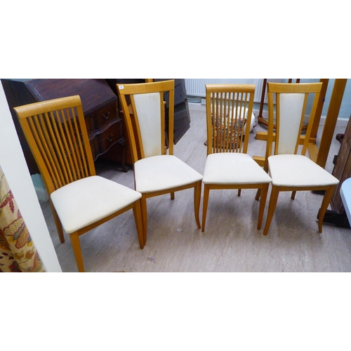 48 - Two dissimilar pairs of light oak framed dining chairs 