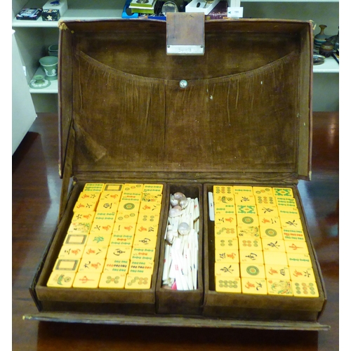 5 - A 1920s/30s Mah Jong set with resin tiles and bone sticks, in a brown hide case