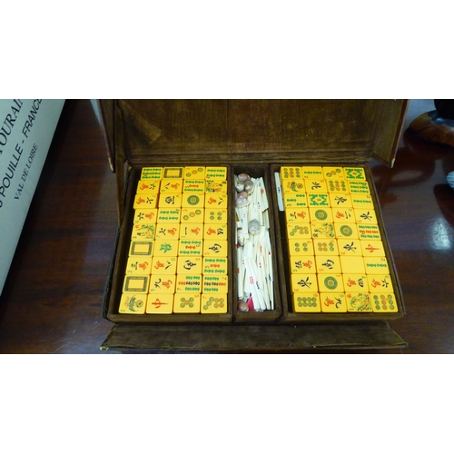 5 - A 1920s/30s Mah Jong set with resin tiles and bone sticks, in a brown hide case