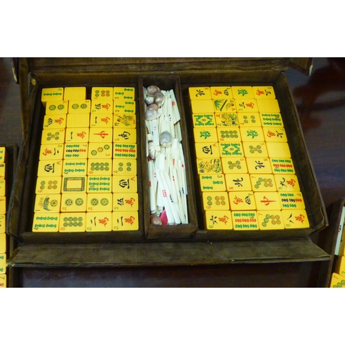 5 - A 1920s/30s Mah Jong set with resin tiles and bone sticks, in a brown hide case