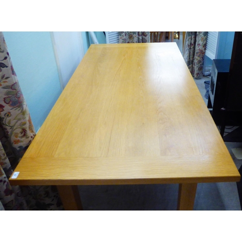 28 - A modern light oak refectory table, raised on square legs  30